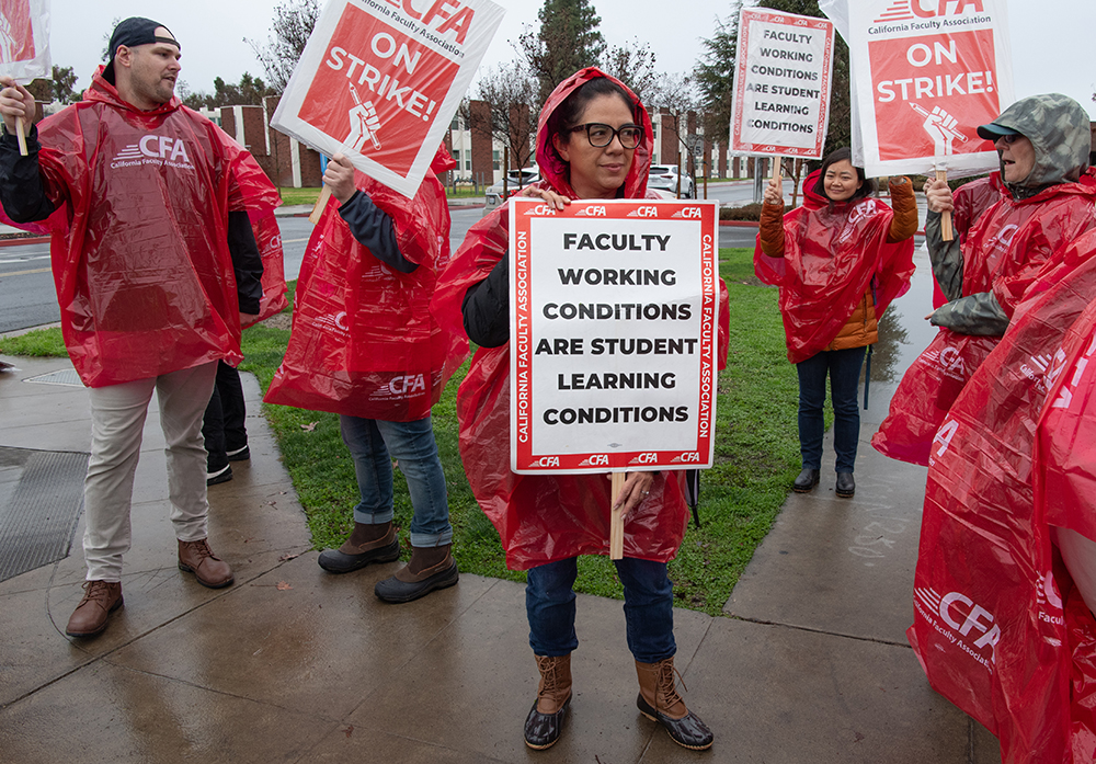 Fresno State faculty in the rain on a picket line on Jan. 22 as part of a statewide strike by the California Faculty Association. Photo by Peter Maiden