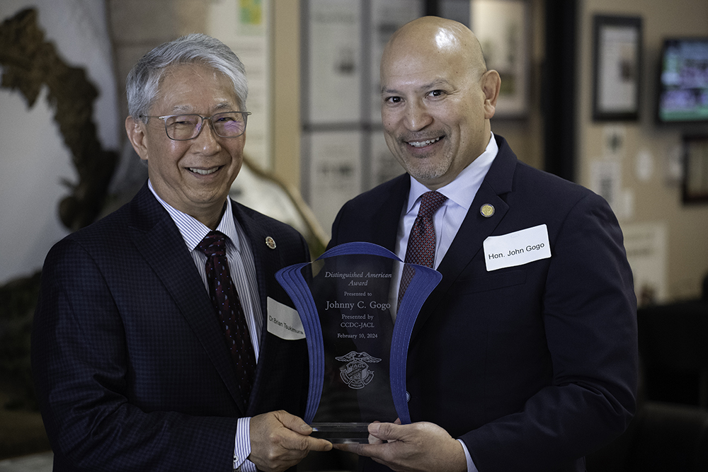 Dr. Brian Tsukimura, left, the governor of the Central California District Council of the Japanese American Citizens League, presents Judge Johnny C. Gogo of the Flag Signing Project with the Distinguished American Award at a Feb. 10 event. Photo by Peter Maiden