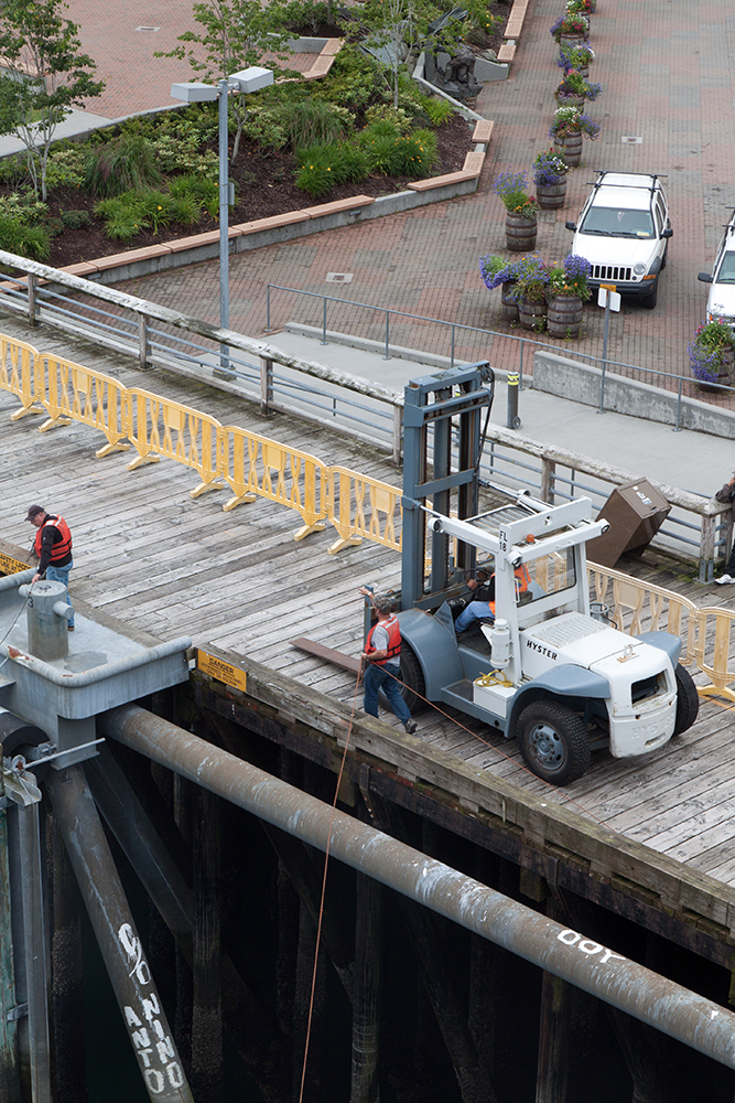 Two workers working on a wooden dock. Automation is affecting workers’ employment in ports around the world. Photo courtesy of The Commons
