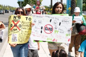 Protesters march with signs made by young children concerned with the genetically modified choices they are flooded with daily.