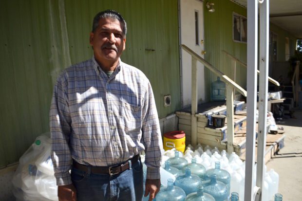 Un residente del condado de Tulare después de recibir agua embotellada que él y su familia usan para cocinar y beber. Foto de Eduardo Stanley