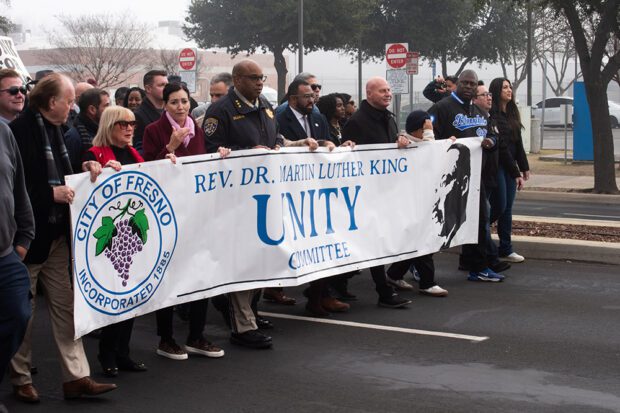 The banner at the front of Fresno’s City-sponsored Dr. Martin Luther King Jr. march on Jan. 20 as it proceeds down Tulare Street, with the participation of elected officials and community leaders. Photo by Peter Maiden