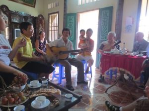 Mr. Viet, a former fighter with the Viet Cong, plays the Vietnamese violin and sings for a small group of Californians in his home outside of Hanoi. Photo by Stacy Moua