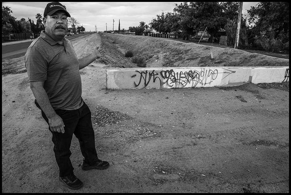 Javier Medina, a community leader, and the ditch that divided Black and White. Photo by David Bacon