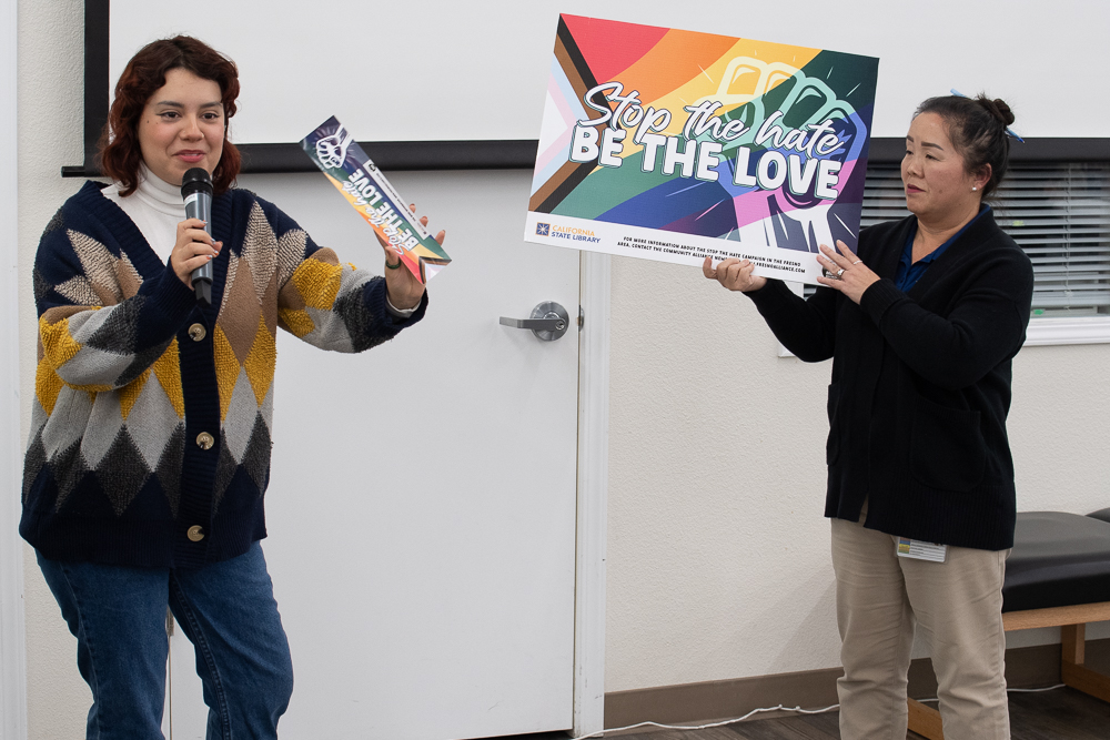 Paulina Cruz, left, and Cyndee Lorylang, right, showed proposals for a lawn sign and a bumper sticker advertising the Stop the Hate Campaign.