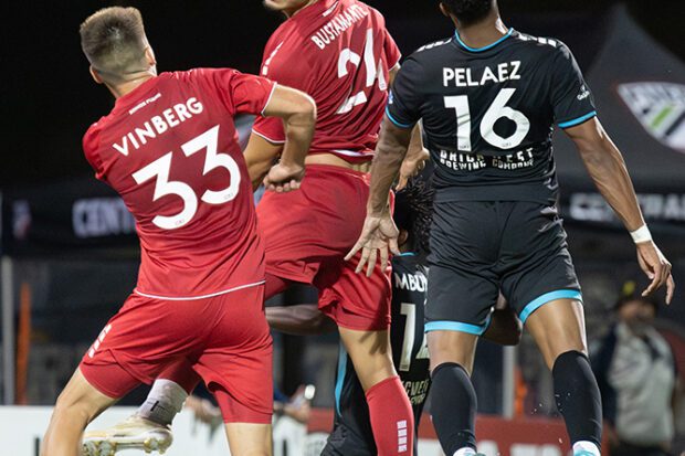 Sean Vinberg y Bryan Bustamante, de Fuego, y Anuar Peláez, de Spokane Velocity, (de izquierda a derecha) disputan un balón cerca de la portería de Fuego. Foto de Peter Maiden