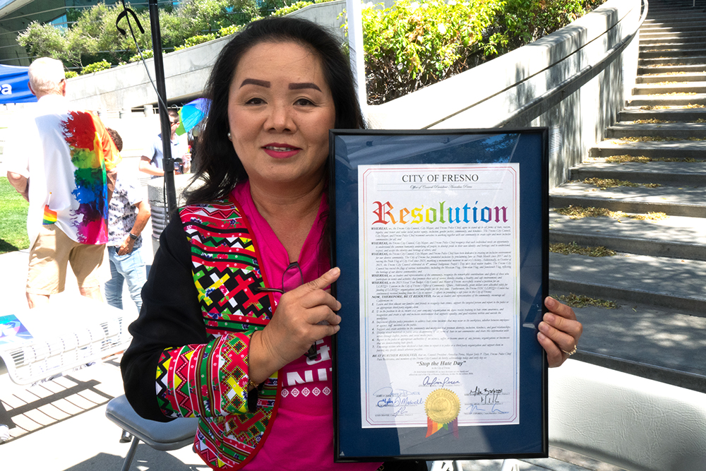 Cyndee Loryang holding the Stop the Hate resolution passed by the City of Fresno. Photo by Eduardo Stanley