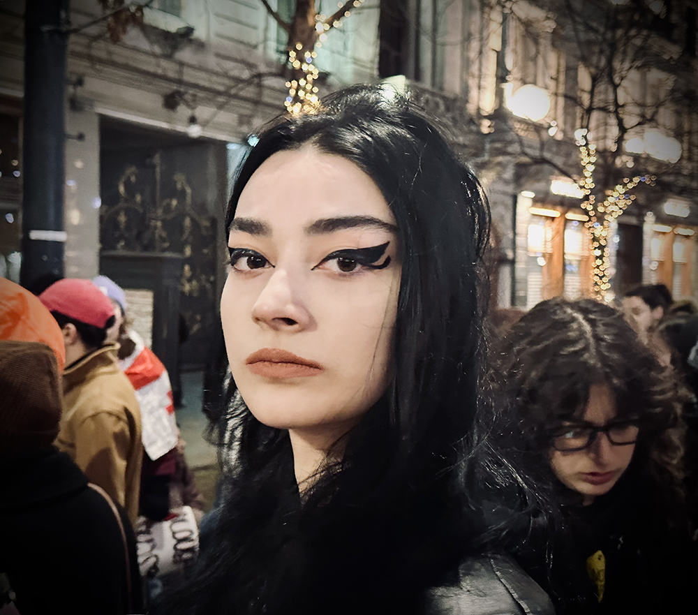 A student protesting in front of the Shota Rustaveli Theater and Film University building.